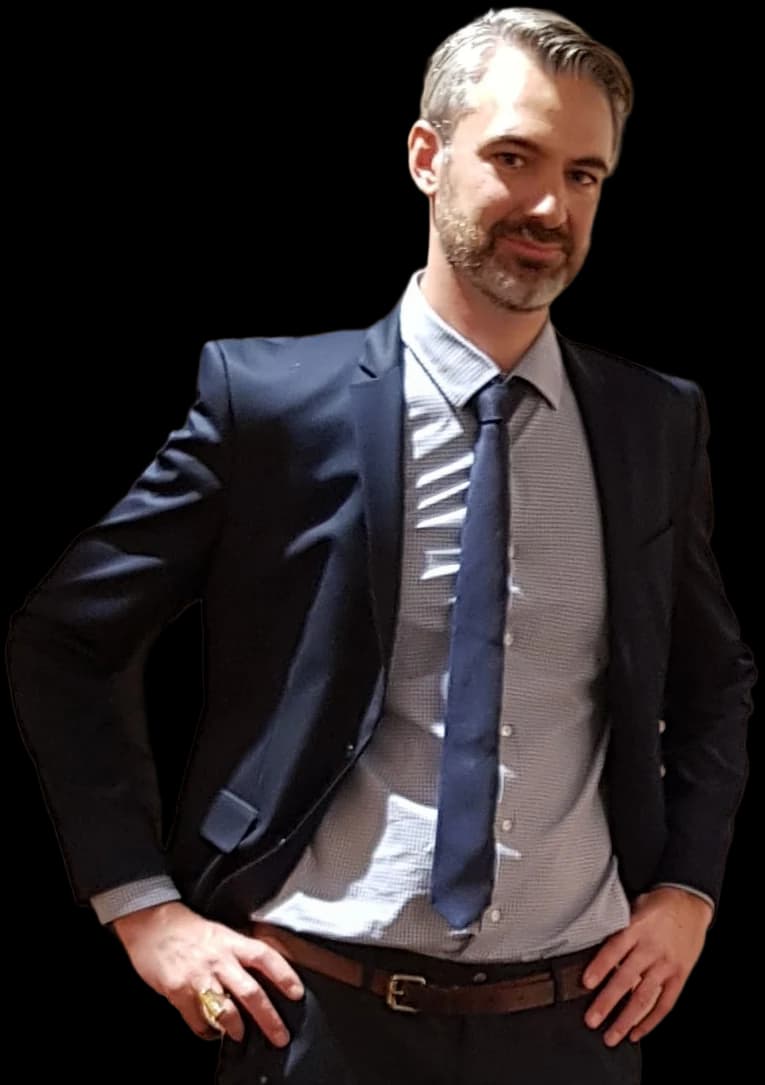 Frederic Merlin, in a dark suit, hands on his hips